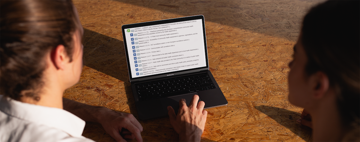 coworkers-using-a-macbook-mockup-on-a-recycled-wooden-desk-a20769
