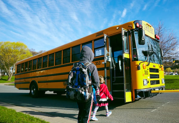 children getting on school bus